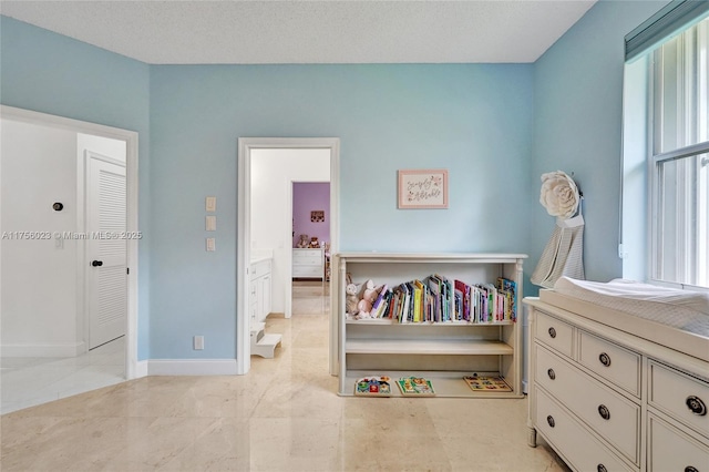 bedroom featuring a textured ceiling and baseboards