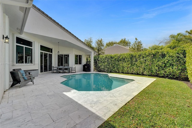 view of pool with a patio, a yard, and a fenced in pool