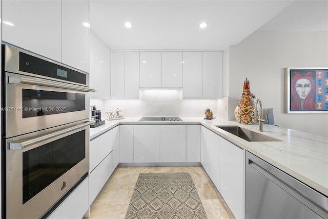 kitchen featuring stainless steel appliances, recessed lighting, white cabinets, a sink, and modern cabinets