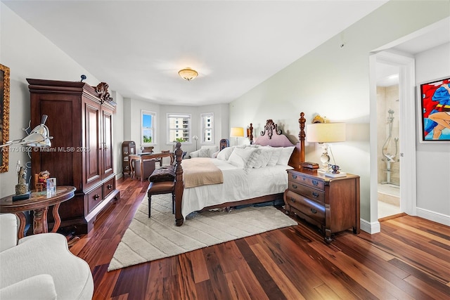 bedroom featuring ensuite bathroom, wood-type flooring, and baseboards