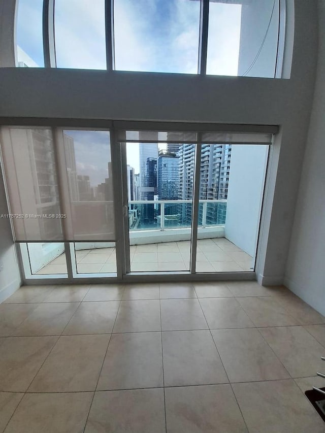 tiled spare room with a city view and a high ceiling