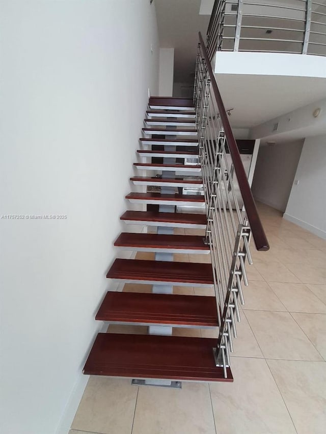 stairway with tile patterned flooring and baseboards