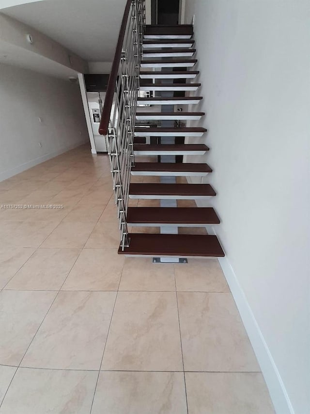 stairway with tile patterned flooring and baseboards