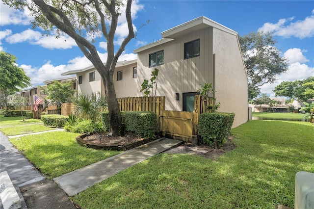 multi unit property featuring stucco siding, fence, and a front yard