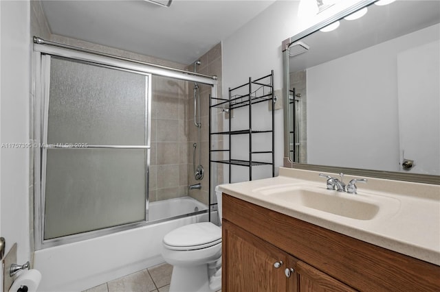 bathroom featuring shower / bath combination with glass door, vanity, toilet, and tile patterned floors