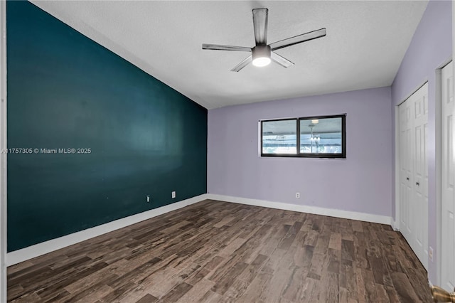 unfurnished bedroom with a ceiling fan, a textured ceiling, baseboards, and wood finished floors