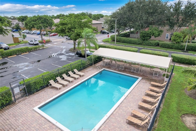 pool featuring a patio, fence, and a residential view