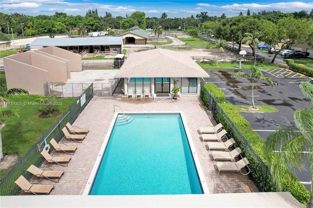 pool with fence and a patio