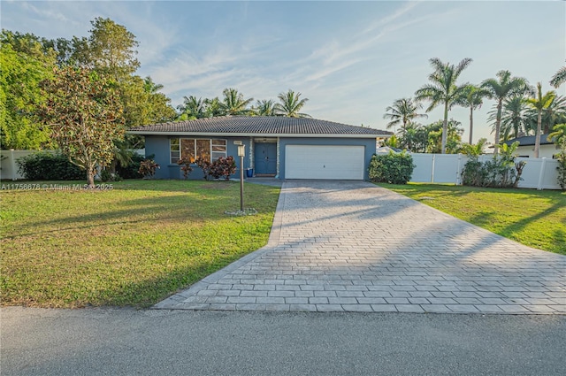 ranch-style home with a front yard, decorative driveway, a tile roof, and an attached garage