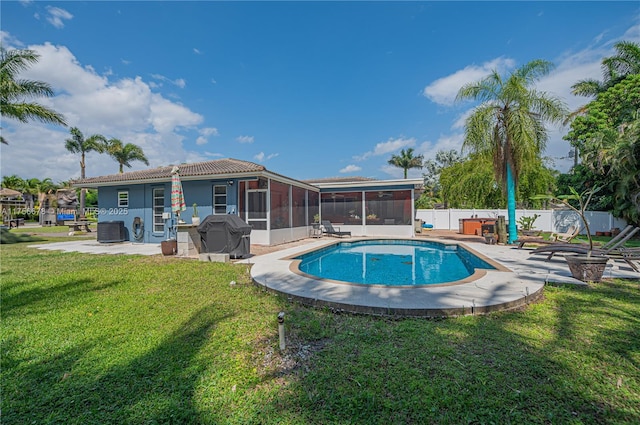 view of swimming pool featuring a patio, a fenced backyard, a sunroom, a lawn, and grilling area