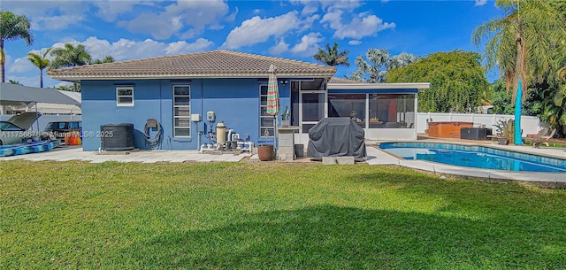 back of property featuring fence, a sunroom, a yard, stucco siding, and a patio area