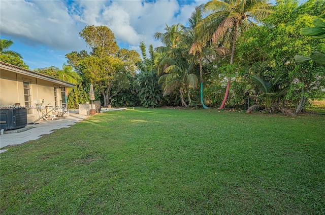 view of yard featuring central AC and a patio area