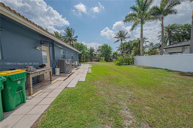 view of yard featuring central AC unit, a patio area, and fence