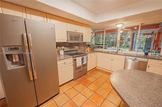 kitchen with appliances with stainless steel finishes, light tile patterned flooring, and a sink