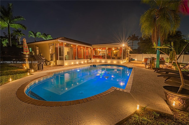 11400 Tara Dr, Plantation, FL 33325 - pool at night featuring a patio and a fenced backyard