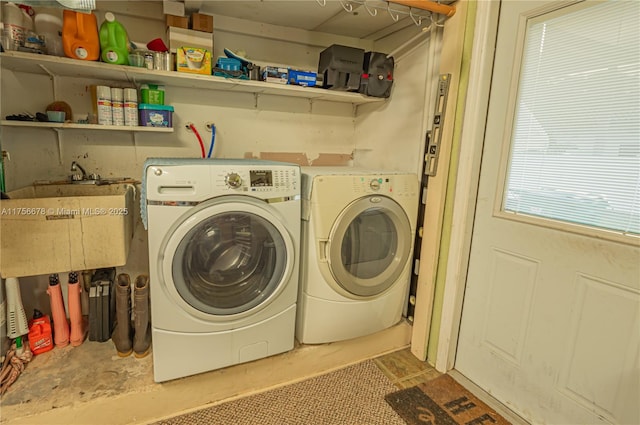 washroom with laundry area, a sink, and washing machine and clothes dryer