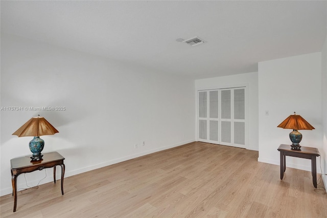 interior space with baseboards, visible vents, and wood finished floors