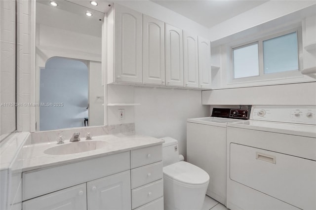 bathroom featuring independent washer and dryer, vanity, and toilet