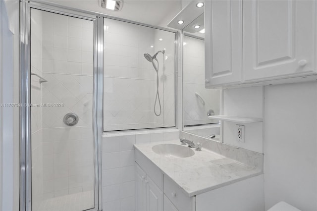 bathroom featuring a stall shower, visible vents, and vanity