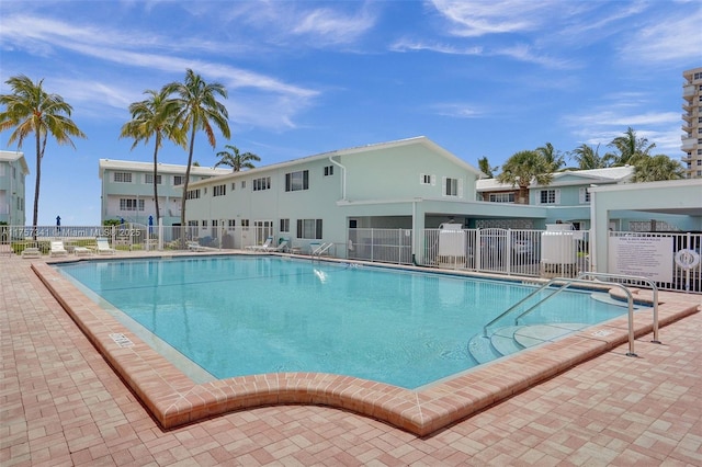 community pool featuring a patio area and fence