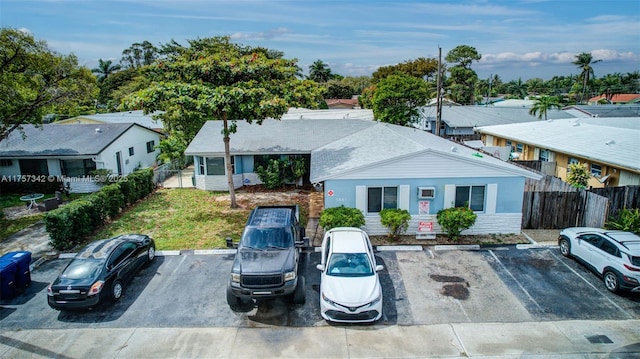 view of front of property featuring uncovered parking, a residential view, and fence