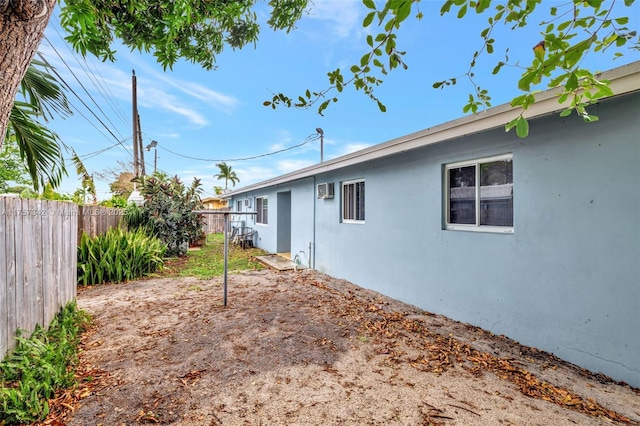 view of yard featuring fence and an AC wall unit