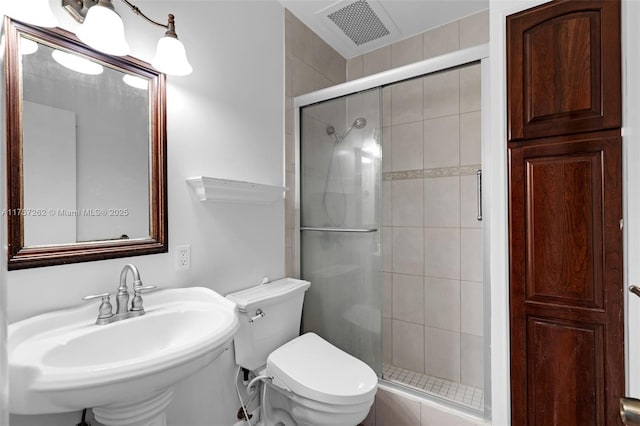 full bath featuring toilet, a shower stall, visible vents, and a sink