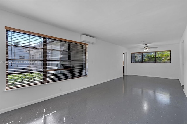 unfurnished room featuring ceiling fan, an AC wall unit, speckled floor, and baseboards