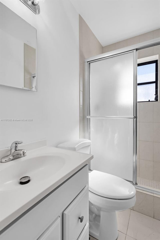 bathroom featuring toilet, a stall shower, and vanity