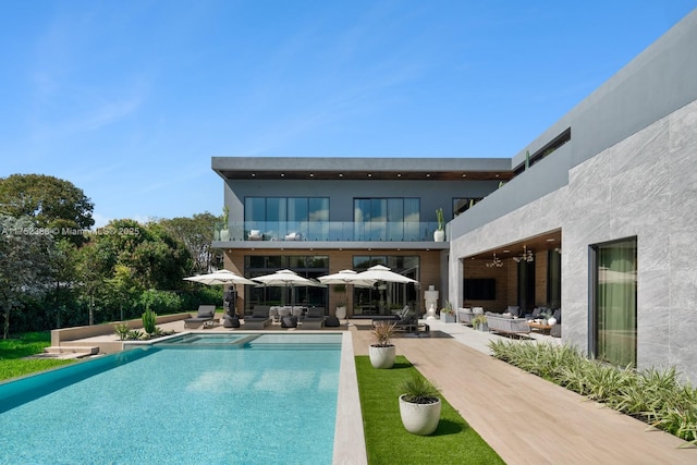 rear view of house featuring outdoor lounge area, ceiling fan, a balcony, and a patio