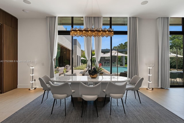 dining space with a chandelier, plenty of natural light, and a wall of windows