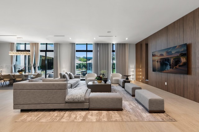 living area featuring wooden walls, expansive windows, and wood finished floors