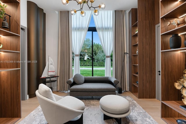 sitting room with light wood-type flooring and a notable chandelier