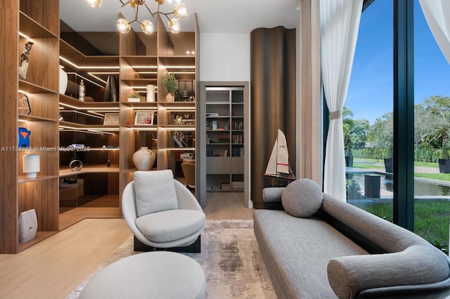 sitting room with wood finished floors and a notable chandelier