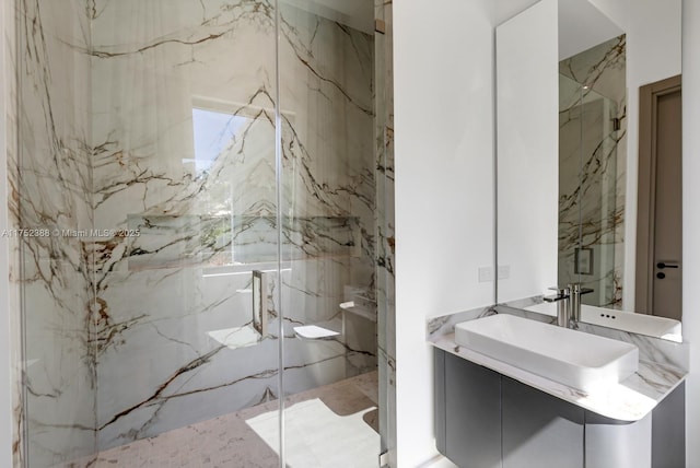 full bath with stone wall, a marble finish shower, and vanity