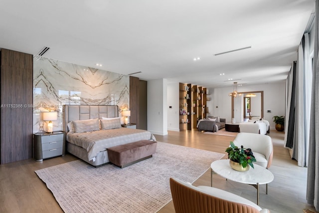 bedroom with recessed lighting, an accent wall, wood finished floors, visible vents, and tile walls