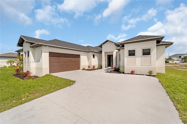 prairie-style home featuring driveway, a front yard, an attached garage, and stucco siding