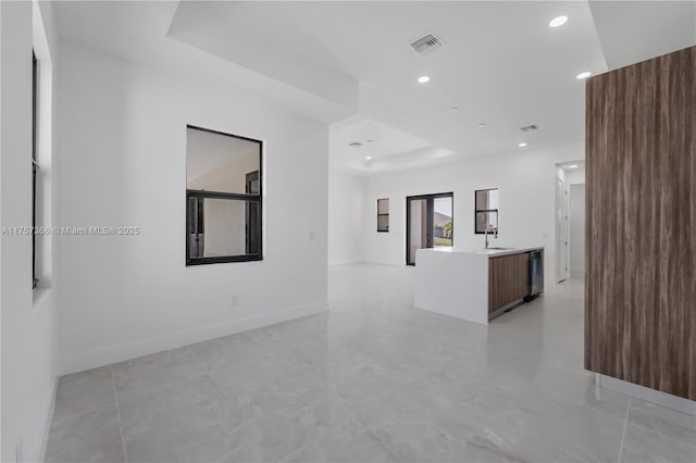 spare room featuring recessed lighting, a sink, visible vents, baseboards, and a tray ceiling