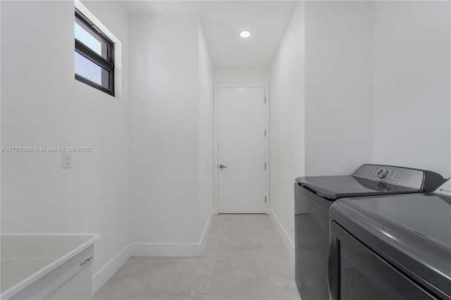 laundry area with baseboards, laundry area, and washer and dryer