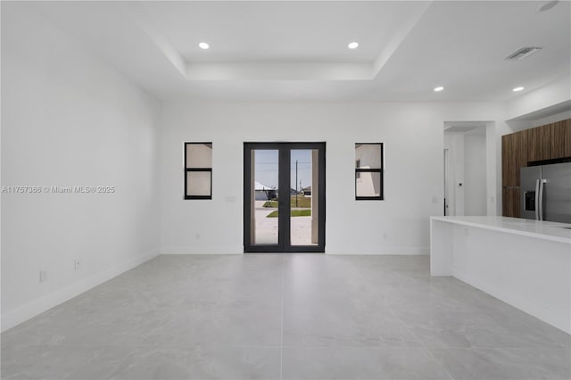 unfurnished room with baseboards, visible vents, a tray ceiling, french doors, and recessed lighting