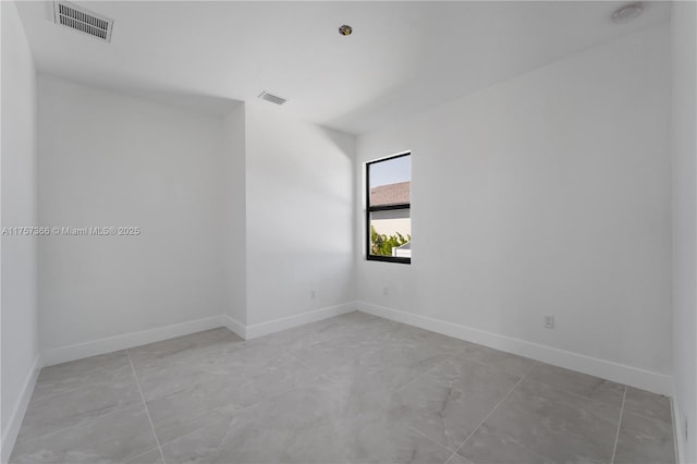 empty room featuring baseboards and visible vents