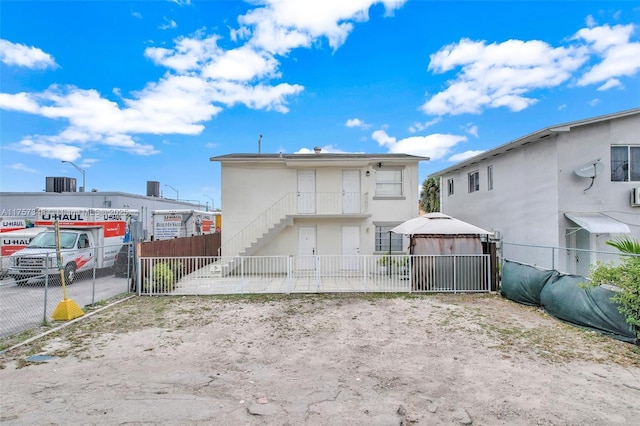 back of property with stairway and fence