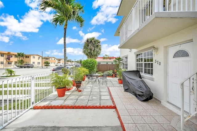 view of patio / terrace featuring a residential view, fence, and outdoor dining space