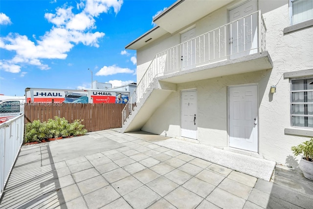 view of patio with stairs and fence