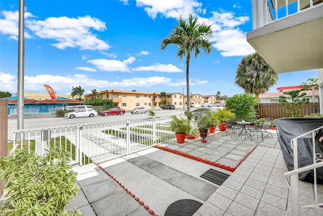 view of patio / terrace featuring outdoor dining area, fence, and a residential view