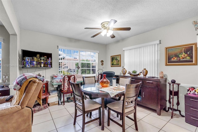 dining room featuring light tile patterned floors, a textured ceiling, and a ceiling fan