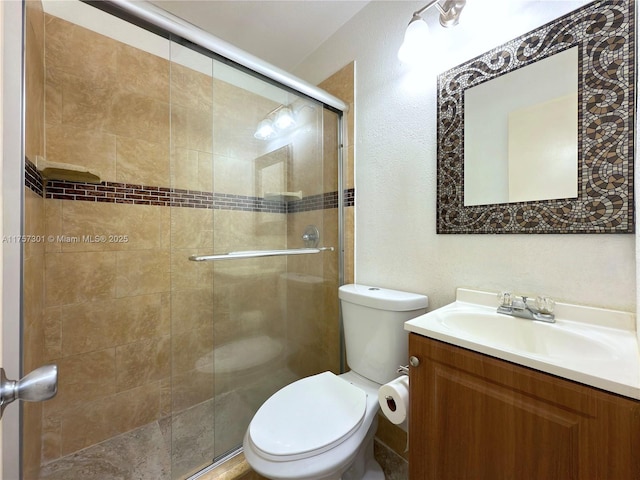 full bathroom featuring a stall shower, vanity, and toilet