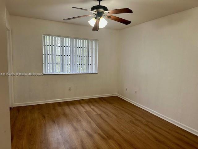 unfurnished room with wood finished floors, a ceiling fan, and baseboards