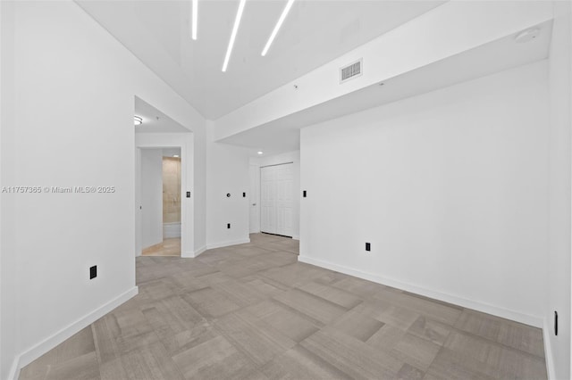 spare room featuring visible vents and baseboards