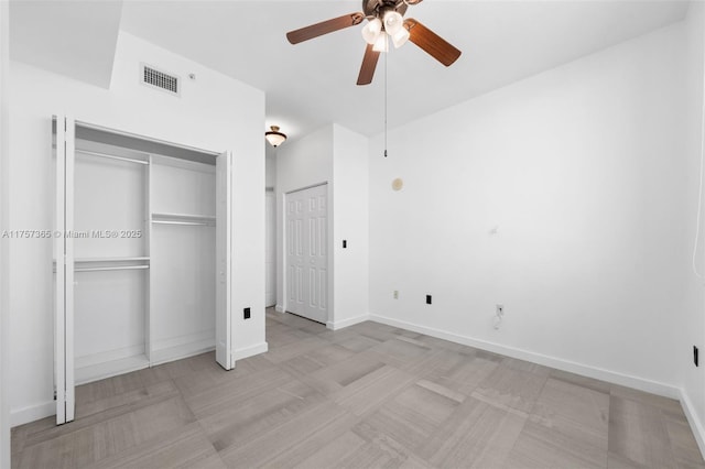 unfurnished bedroom with visible vents, baseboards, and two closets